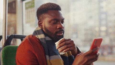 African american man is sick of flu sneezing allergy using paper napking sitting inside tram driving to work on public transport. Unhealthy business people.