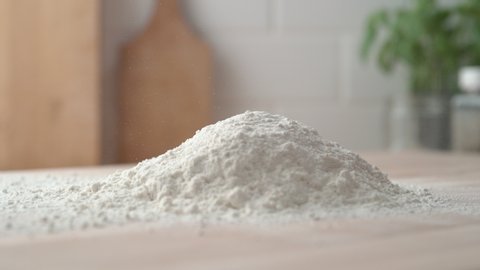 Pouring flour onto a cooking table. Slow Motion.