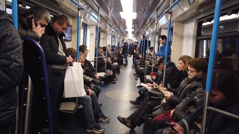 MOSCOW, RUSSIA - 12 DECEMBER 2019: People in the subway car. Moscow metro. Passengers sit in places with different activities.