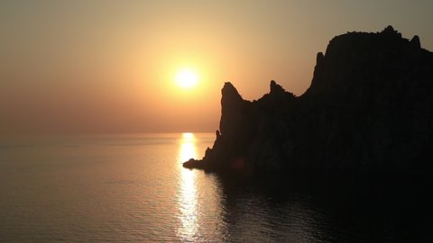 Silhouette of Karaul-Oba mount, edge of the ancient coral reef of the Jurassic period. Sunset view on mountain in shape of rhinocerous from cape Kapchik. Crimea.