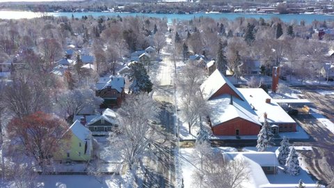 Scenic small town under deep, fresh snow, early morning in Winter, aerial view.
