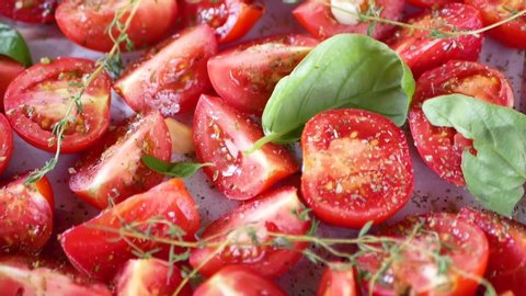 Tomatoes on a baking sheet. in front of the oven. No pesticides. Eco vegetables. Tomatoes on a baking sheet, aromatic herbs, thyme, top view. Italian cuisine, tomatoes on a baking sheet with aromatic