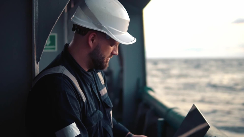 Marine chief officer or captain on deck of vessel or ship watching laptop. Internet and home connection at sea. Royalty-Free Stock Footage #1043046148
