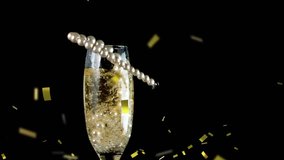 Animation of string of pearls falling into champagne glass with golden confetti falling during New Year Eve celebrations - Powered by Shutterstock - Get 15% off with code: PIKWIZARD15