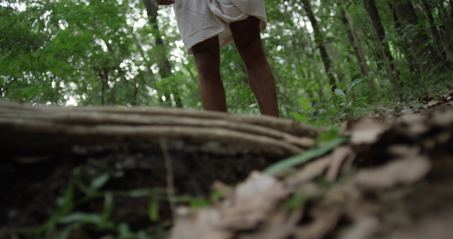 The man walks barefoot with a mountain in the woods