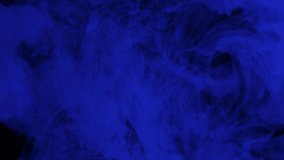 Dark blue ink mixing in water, swirling softly underwater with copy space. Colored acrylic cloud of paint isolated. Colorful abstract smoke explosion animation. Universe, space. Art background. 4K