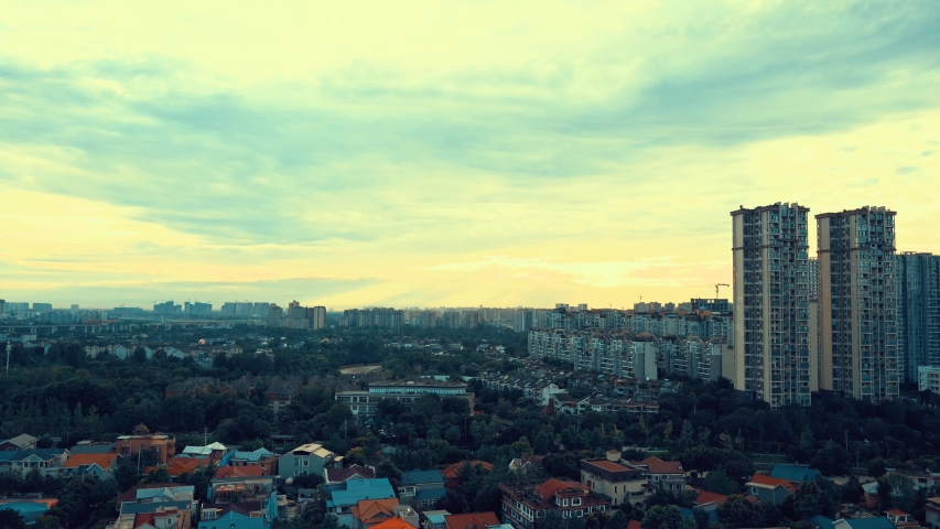 Chengdu, Sichuan, China.  Time lapse during the sunset in the evening on the Jinyang and Wuhou districts. Metropolis lights and beautiful sky at dusk, view from the roof. Old and modern buildings.