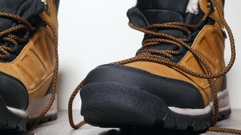 Men Fashion Brown Leather Boots Shoes With Laces On Top A Wooden Floor Background Panning Slider Shot.