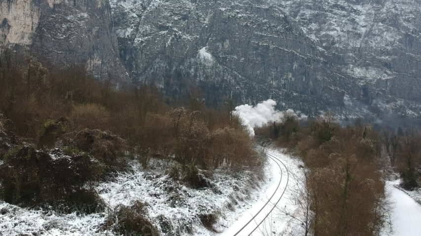 Historic steam train rolling through the snowy valley in a winter day Royalty-Free Stock Footage #1043112217