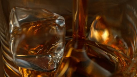 Super Slow Motion Macro Shot of Pouring Whiskey into Glass with Ice Cubes at 1000fps with Camera Movement.