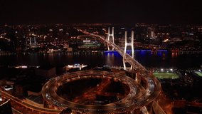 Nanpu Bridge in 4k aerial video scene of drone fly over the bridge, dolly and pan shot of the landmark in Shanghai, China at night time with crowded traffic on road