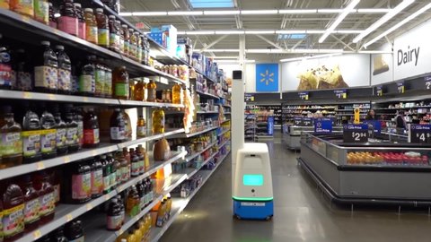 Somerdale, New Jersey - December, 2019: A rolling robot rolls down an aisle as it shines a light on shelves while taking product inventory at a  Walmart store