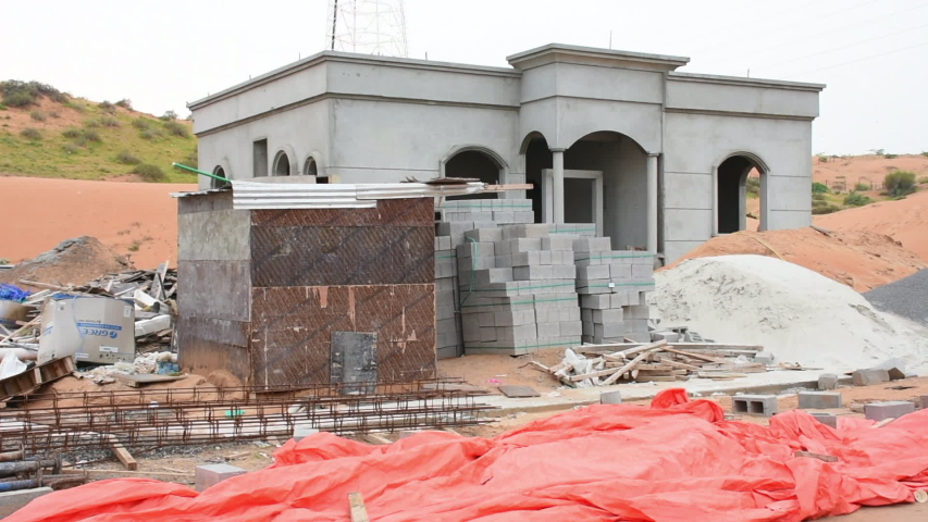 New contruction housing project in the desert of the United Arab Emirates with a concrete shell and supplies