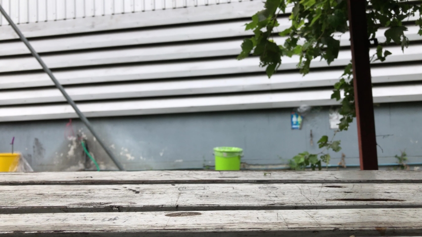 Perspective of wood table top and blurred atmosphere in warehouse, metal sheet wall, with lens flare,free space for your text design.