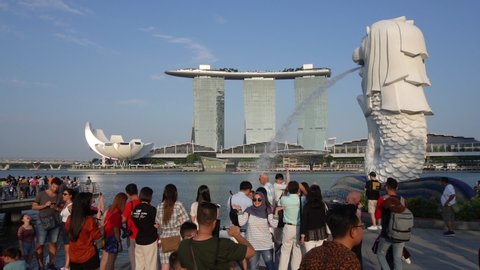 SINGAPORE-JULY, 2019: Slowmotion of city landmark - Marina Bay and Merlion lion fountain. People walking around
