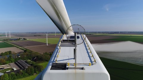 Aerial close up footage of wind turbine providing sustainable energy by spinning blades the power also known as renewable is collected from resources green field meadow in background 4k quality