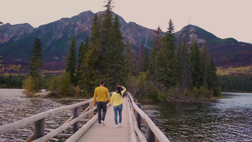 couple by the lake watching sunset, Pyramid lake Jasper during autumn in Alberta Canada, fall colors by the lake during sunset, Pyramid Island Jasper