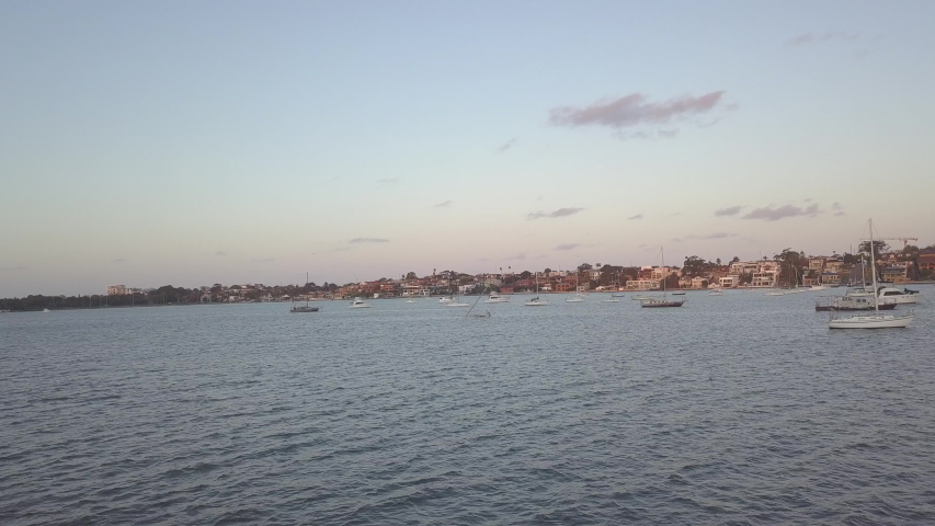 Aerial low shot of many moored small boats near the coast of Australia.