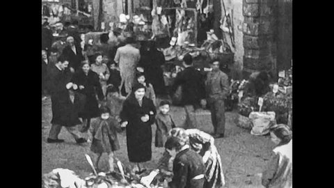 Naples, Italy, 1955 - Several people crowd the shops and stalls of a typical Neapolitan street