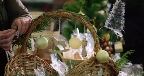Girl decorates a basket with decorative toys. Festive mood. Christmas preparations. 4k. Slow motiom