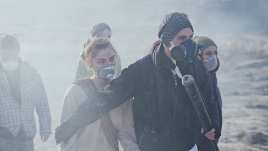 Group of survivors in post apocalyptic wasteland are defending from the enemy with baseball bat. Royalty-Free Stock Footage #1043142364
