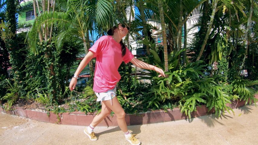 Tropical plants and a lady dancing playfully next to them