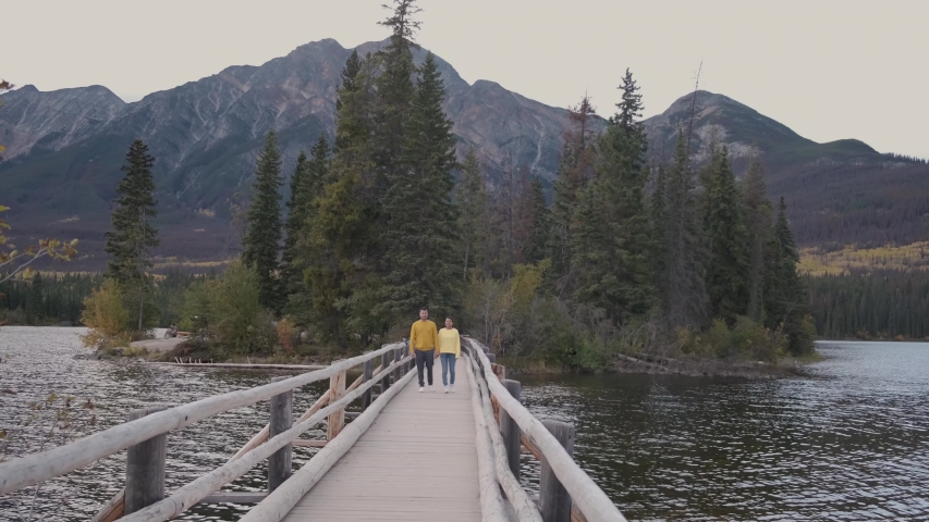 couple by the lake watching sunset, Pyramid lake Jasper during autumn in Alberta Canada, fall colors by the lake during sunset, Pyramid Island Jasper