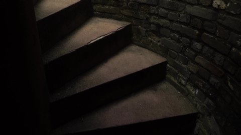 man climbs a Dark spiral staircase