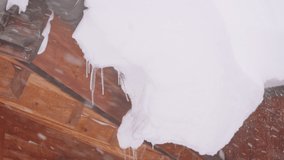 Heavy snowfall in a wintry mountain alpine village, large snow cornice on a roof - Powered by Shutterstock - Get 15% off with code: PIKWIZARD15