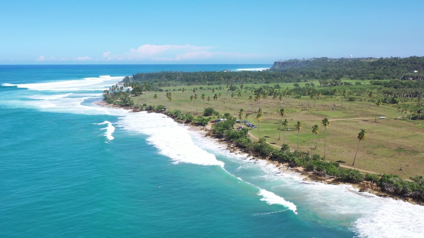 Aerial view of playuelas beach in Aguadilla, Puerto Rico with several surfers in the water