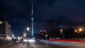 Car traffic in Berlin city center at night. Panoramic view with illuminated Fernsehturm (Berlin TV tower), one of the most important landmarks of the city. Time lapse video.