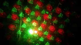 The projector projected Christmas motifs on a black surface. It consists of red and green projector colors. The motives are: star, Santa Claus, xmas and others.
