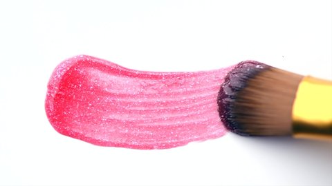 Lipgloss make-up smudge, smear. Cosmetic liquid lip gloss, lipstick pink color smudge, smear, stroke. Lip gloss Make up smears isolated on a white background. Brush. Smooth Texture. 4K UHD video