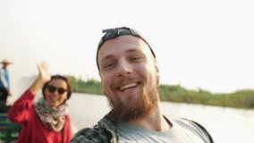 Young Tourist Couple Recording Selfie Video, Waving Hands on Wide Angle Camera while Riding on Boat. Wild Tourism Adventure Natural Exploration Concept 4K Slowmotion Footage. Inle lake, Myanmar.
