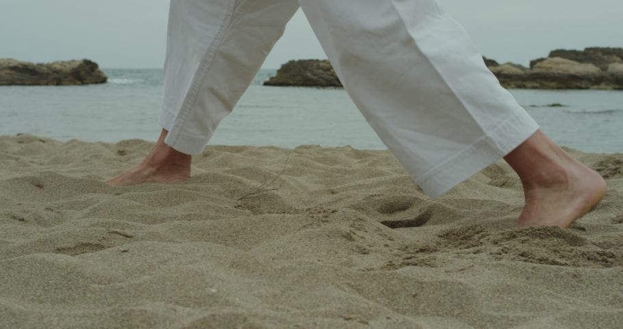 Karate black belt practicing some kata movements in the beach. Focusing on the feet movements. Slow motion. Shot on RED SCARLET-W with LEICA R lenses. | Shutterstock HD Video #1043251186
