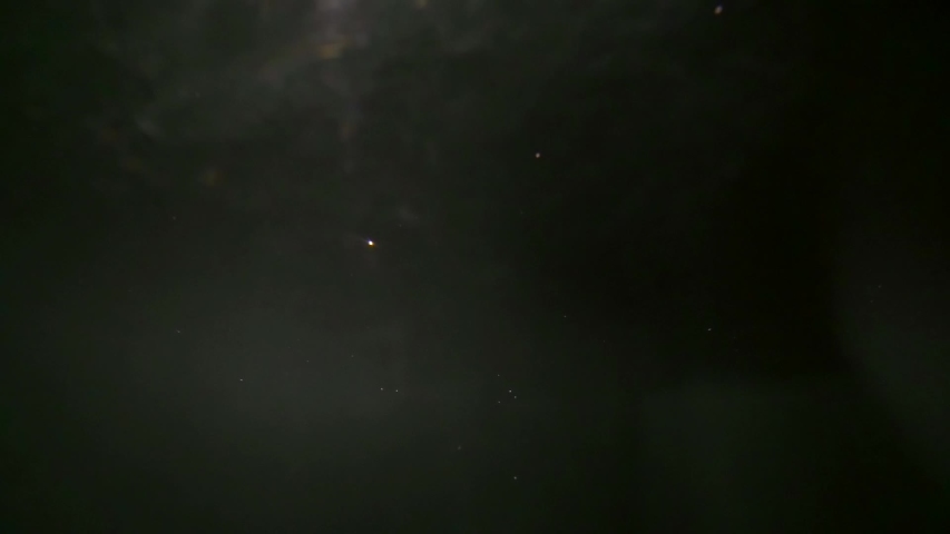 close up of a dark haired girl falling into the water she is underwater on a blue background. Splashes and splashes of water everywhere.