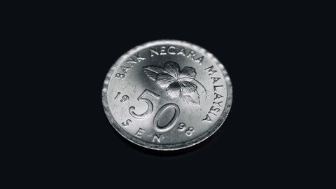 Malaysian coin 50 sen 1998 release rotates on a black background. Macro. Closeup