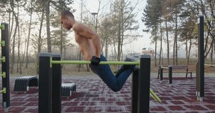 Man doing triceps exercise on parallel  bars in the park 