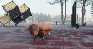 Man doing chest and triceps push ups in the park 