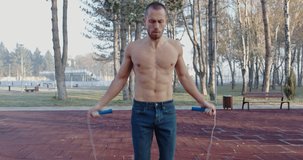 topless man jumping rope in the park 