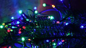 Blinking colored Christmas lights with green fir branch. Christmas atmosphere. 4K UHD Video
