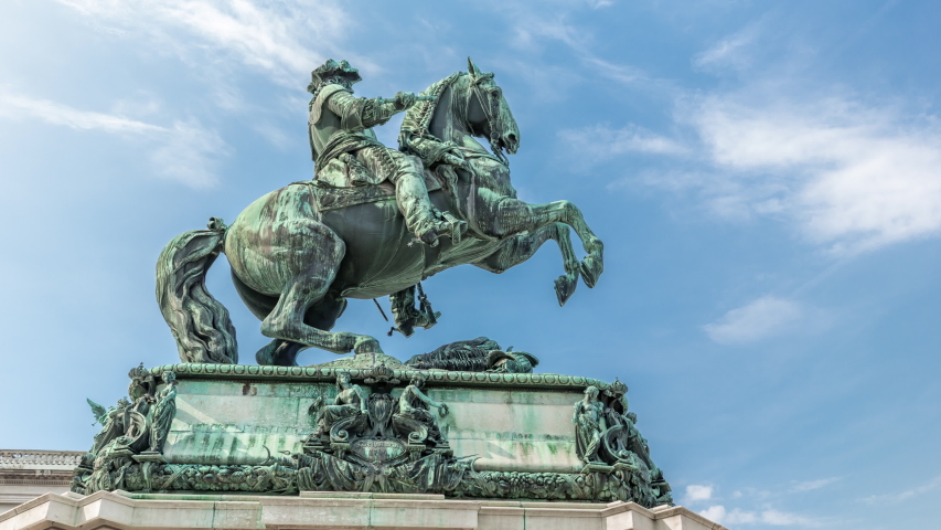 Equestrian statue of Prince Eugene of Savoy timelapse hyperlapse (Prinz Eugen von Savoyen) in front of Hofburg palace, Heldenplatz, Vienna, Austria. Blue cloudy sky