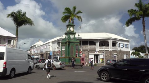 Basseterre / St Kitts & Nevis - December 2019: People and cars.   Clock Tower in the busy center of capital, Piccadilly Circus