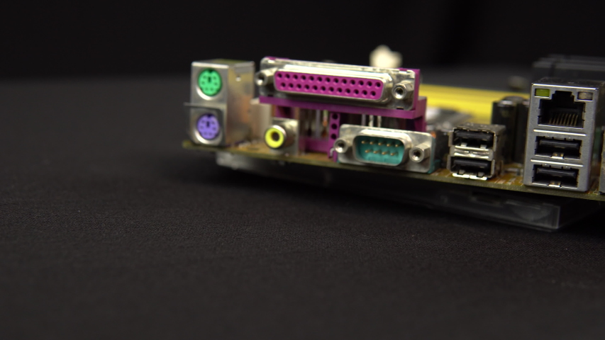Side view of the inputs of the motherboard. Motherboard PC base part. A lot of different chips. View of the computer dismantled.