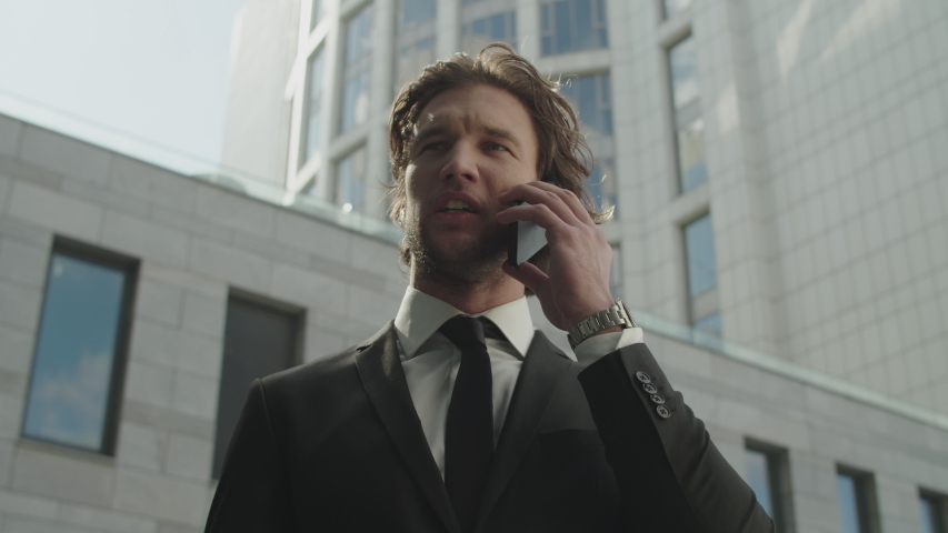 A young businessman is talking on the phone. He argues and tries to prove his case.