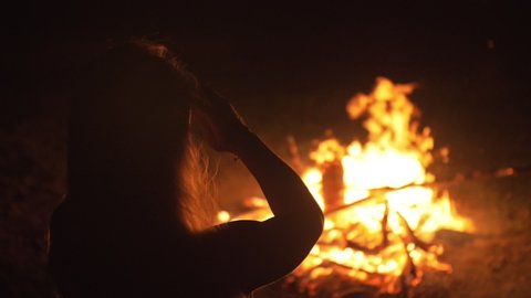 Silhouette of mystic woman in black background of fire fly flame, spark, of contour outline. Adult sexy of young girl witchcraft ceremony ritual dance in underclothes. Outdoor slow motion. Caucasian.