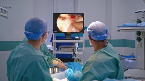 Endoscopic surgery on the monitor. Surgeons perform an operation and look at the screen of a monitor in the operating room. Modern technologies in medicine.
