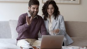 Happy woman and man having video call through laptop. Smiling young couple talking with interlocutor through laptop. Communication and technology concept