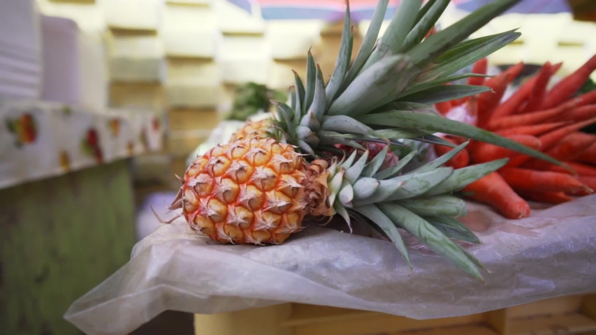 Ascending shot, Pineapples and other Fruits and vegetables at Rouseau market in Dominica.