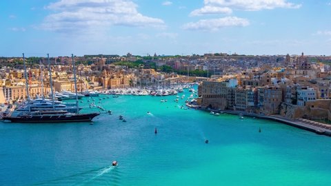 Malta. View from Valletta coast to the Birgu city with Fort St. Angelo, marina with a lot of ships and luxury yachts in azure sea. Time lapse
